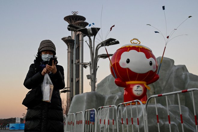 Ali tudi maskota olimpijskih iger gleda čez ramo obiskovalki Pekinga? FOTO: Jade Gao/AFP
