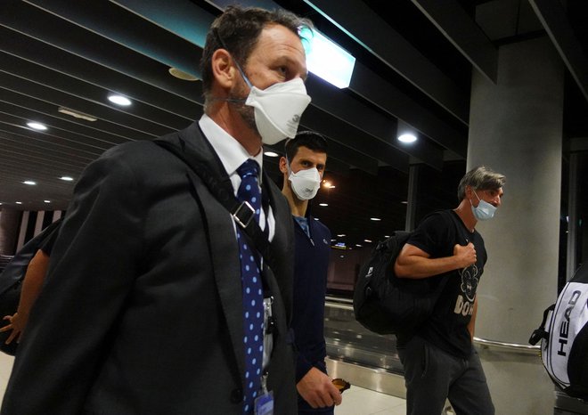 Novak Đoković (v sredini) se je medtem že odpravil na letališče v Melbournu in zapustil Avstralijo. FOTO: Loren Elliott/Reuters
