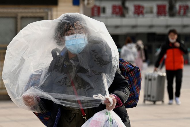 Ženska, ki uporablja plastično vrečko za dodatno zaščito, se sprehaja pred pekinško železniško postajo v Pekingu. Na Kitajskem je vse v znamenju največjega praznika v letu, lunarnega novega leta, ki bo letos v znamenju tigra. Foto: Noel Celis/Afp

 
