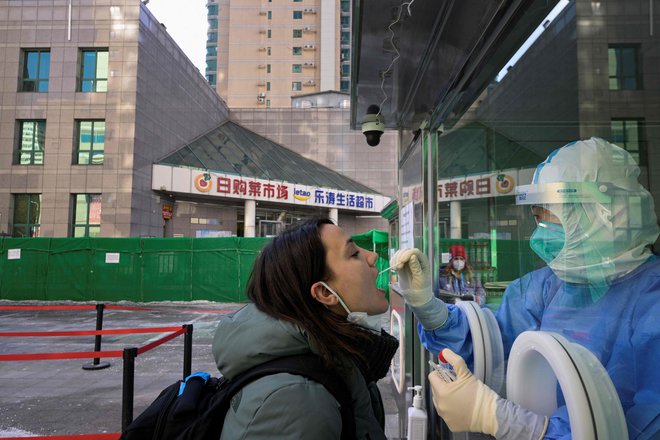 V Pekingu velja strog koncept ukrepov za preprečevanje širjenja virusa. FOTO: Sebastien Bozon/AFP
