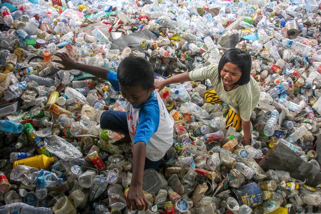 Otroci se igrajo med kupi plastičnih odpadkov v indonezijskem mestu Makassar. Foto: Andri Saputra/Afp

&nbsp;
