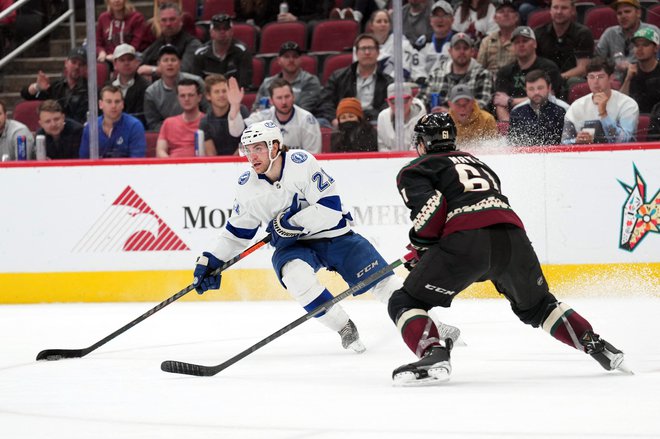 Brayden Point (v belem dresu) prodira s ploščkom ob branilcu Arizona Coyotes&nbsp;Dysinu&nbsp;Mayu&nbsp;v zadnji tretjini tekme v dvorani Gila River Arena. FOTO: Joe Camporeale/USA Today Sports
