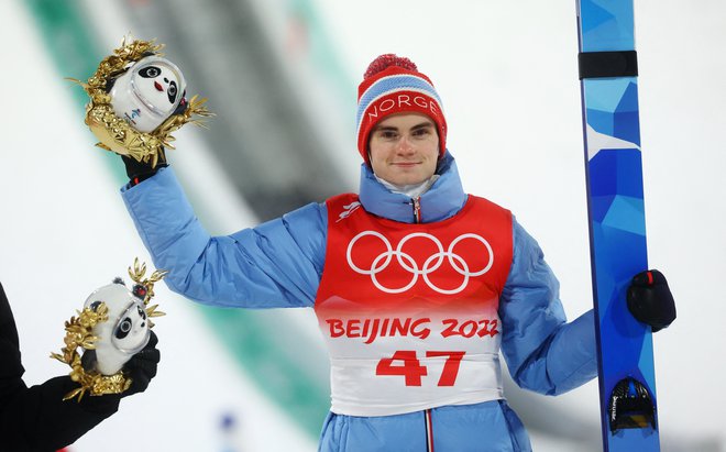 Marius Lindvik je olimpijski šampion, v drugi seriji je preskočil odličnega Rjojuja Kobajašija in mu iz ro iztrgal drugo zlato kolajno. FOTO: Kai Pfaffenbach/Reuters
