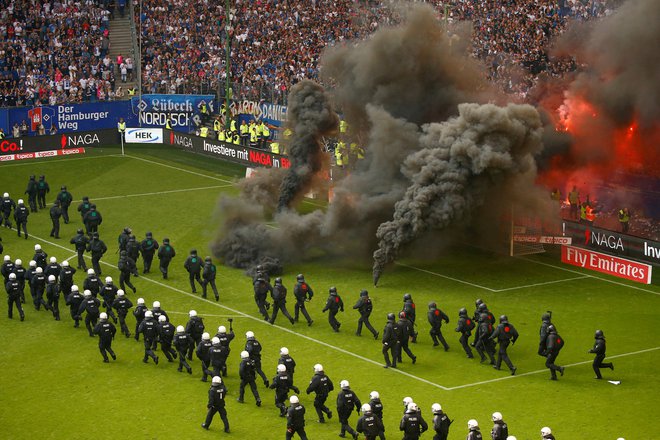 Prizor iz leta 2018, ko so navijači Hamburga začinili tekmo z Borussio z metanjem pirotehničnih sredstev. FOTO: Morris Macmatzen/Reuters
