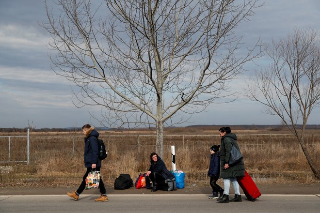 Ljudje iz Ukrajine bežijo proti Madžarski, potem ko je Rusija začela z vojaško invazijo. FOTO: Bernadett Szabo/Reuters
