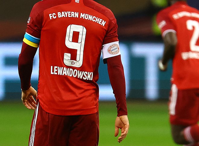 Robert Lewandowski je v Frankfurtu kot kapetan Bayerna v znamenje podpore nosil tudi trak v barvah ukrajinske zastave. FOTO: Kai Pfaffenbach/Reuters
