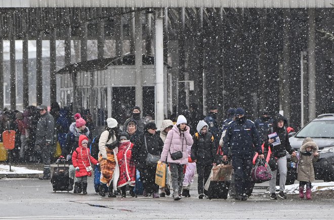 Begunci, ki prihajajo iz Ukrajine, na ukrajinsko-romunski meji v Siretu. FOTO: Daniel Mihailescu/AFP
