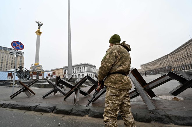 Borec ukrajinskih teritorialnih obrambnih sil varuje protitankovske konstrukcije na položaju na Trgu neodvisnosti v Kijevu. FOTO: Sergei Supinsky/AFP
