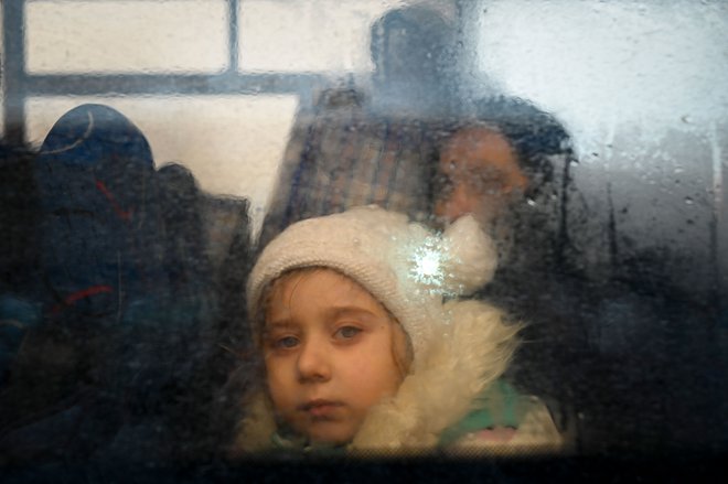 Deklica na avtobusu z begunci na poti v moldavsko prestolnico&nbsp;Kišinjev. FOTO: Nikolay Doychinov/AFP
