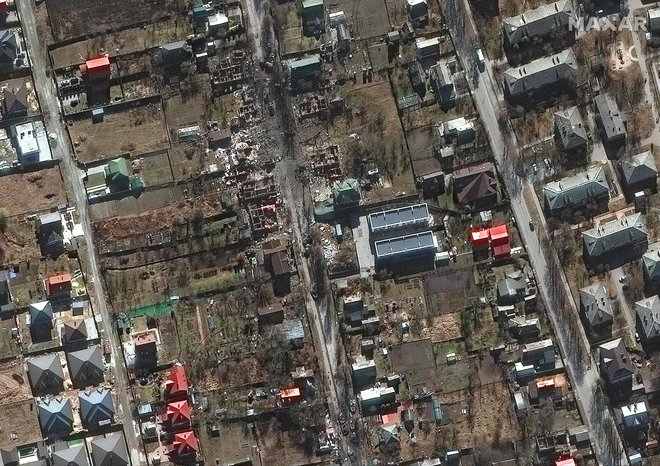 Satelitski posnetek, ki ga je objavil Maxar Technologies, prikazuje uničena vojaška vozila v stanovanjskem območju in uničene domove na ulici Vokzalna v Buči v zahodnem Kijevu. FOTO: AFP
