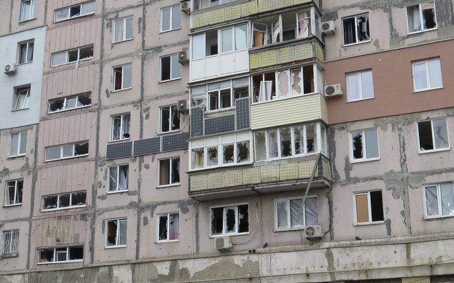 Uničene stanovanjske stavbe v Mariupolju niso popolnoma prazne, lačni in premraženi stanovalci se že dneve skrivajo na hodnikih in po kleteh, iz mesta pa ne morejo. Foto Nikolaj Rjabčenko/Reuters
