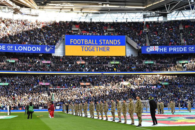 Finalna tekma angleškega ligaškega pokala je na Wembleyju nedavno minila povsem v znamenju ukrajinske rumeno-modre zastave, kapetana Chelseaja in Liverpoola sta na zelenico prinesla tudi cvetje. FOTO: Justin Tallis/AFP
