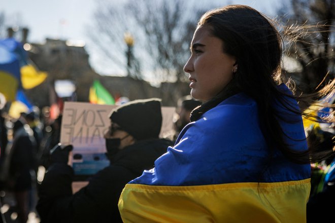 Ženska nosi ukrajinsko zastavo na shodu v podporo Ukrajini v Washingtonu. FOTO: Samuel Corum/AFP
