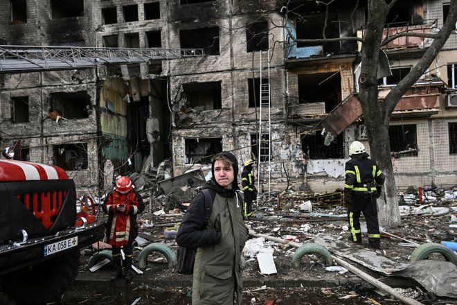 Osemnajstletnik v enem od uničenih predmestij Kijeva. FOTO: Aris Messinis/AFP
