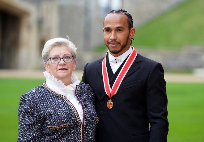 Lewis Hamilton se je fotografiral z mamo&nbsp;Carmen, ko je lani prejel viteški naziv. FOTO: Andrew Matthews/Reuters
