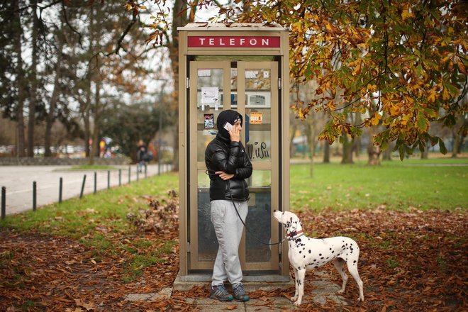 Telefoniranje ob telefonski govorilnici v Parku Tivoli. FOTO: Jure Eržen/Delo
