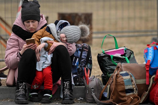 Ukrajinske ženske rešujejo otroke na poti v neznani svet. FOTO:&nbsp;Louisa Gouliamaki/AFP
