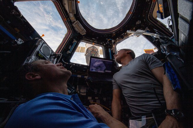 Ameriška astronavta Mark Vande Hei (desno) in Thomas Marshburn gledata Zemljo skozi znamenito kupolo. FOTO: Nasa
