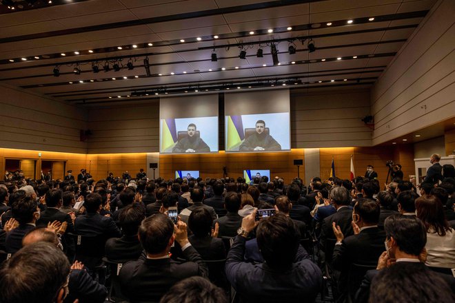 Videonagovor ukrajinskega predsednika Volodimirja Zelenskega so tudi v japonskem parlamentu pozdravili s stoječimi ovacijami. FOTO: Behruz Mehri/AFP
