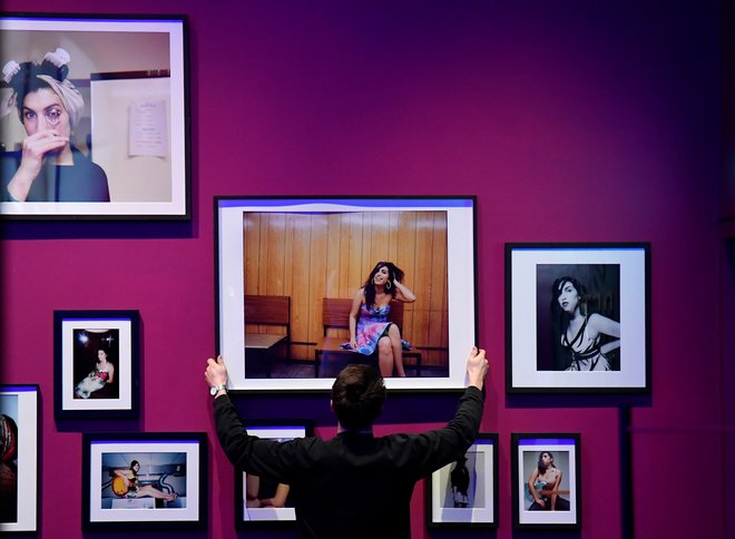 Stena s fotografijami v londonskem Design Museum z razstavo Amy, onkraj odra. FOTO: Toby Melville/Reuters
