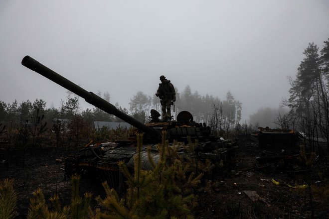 Ukrajinski vojak fotografira ruski tank na obrobju Kijeva. FOTO: Ronaldo Schemidt/AFP
