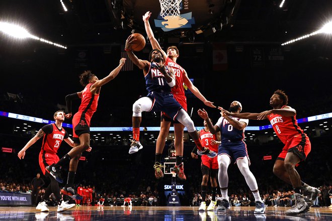 Kyrie Irving prodira proti košu ob&nbsp;Alperenu Sengunu (št. 28)&nbsp;v domači dvorani&nbsp;Barclays Center. FOTO:&nbsp;Sarah Stier/AFP
