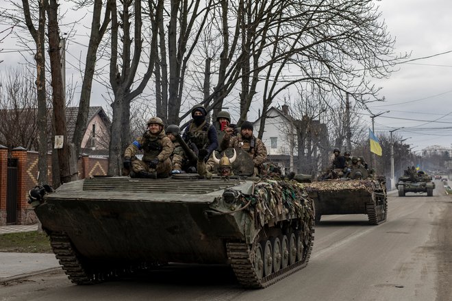 Ukrajinski vojaki na tankih v Buči. FOTO: Alkis Konstantinidis/Reuters
