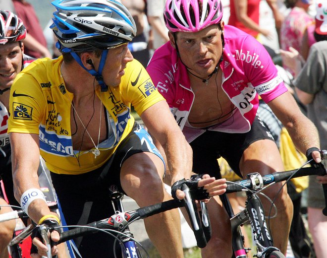 Jan Ullrich, desno ob Lanceu Armstrongu, je znamenito kolo s Toura podaril za dražbo, namenjeno zbiranju pomoči za Ukrajino. FOTO: Franck Fife/Reuters
