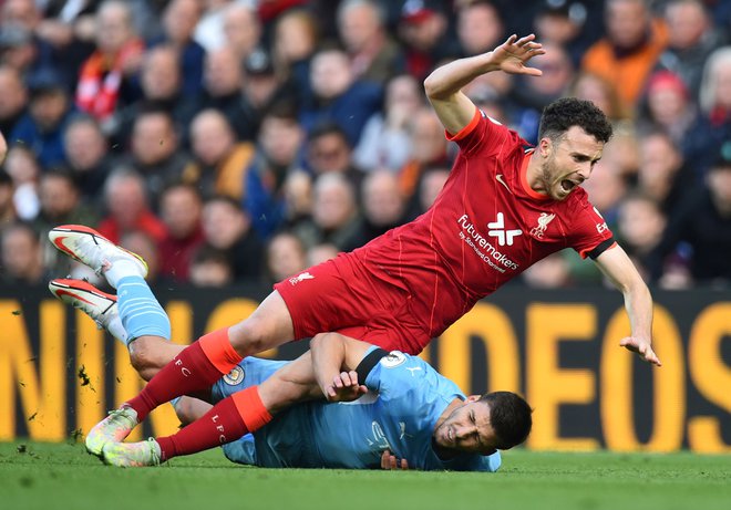 Na zadnji medsebojni tekmi oktobra na Anfieldu je bil izid 2:2. Na fotografiji dvoboj Portugalcev Dioga Jote (zgoraj) in Rubena Diasa. FOTO: Peter Powell/Reuters
