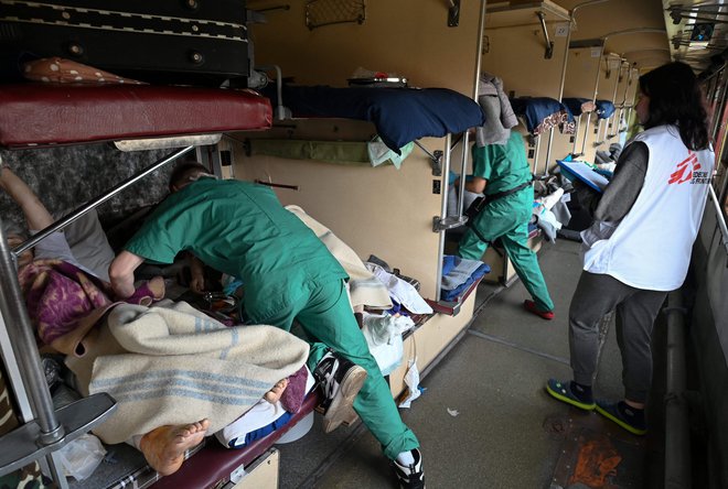 Skrb Zdravnikov brez meja za paciente med evakuacijo na vlaku za Lvov. Bolnike so evakuirali iz bolnišnic na vzhodu države. FOTO: Genya Savilov/AFP
