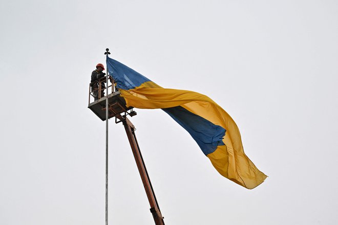 Postavljanje ukrajinske zastave v središču Makariva v kijevski regiji. FOTO: Sergei Supinsky/AFP
