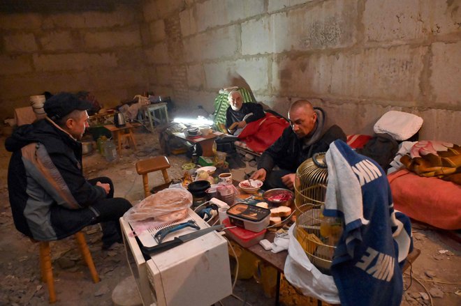 Življenje v zaklonišču v kletnih prostorih večnadstropne stavbe v Harkovu. FOTO: Sergey Bobok/AFP
