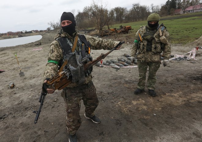 Ukrajinska vojaka z mitraljezom z uničenega ruskega tanka. FOTO: Reuters
