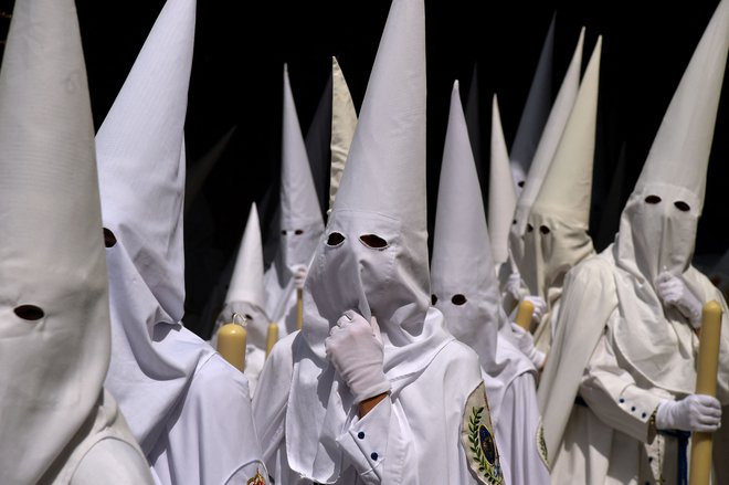 Kesanci bratovščine La Paz na procesiji na cvetno nedeljo v Sevilli. Krščanski verniki po vsem svetu obeležujejo verski teden pred veliko nočjo, ko praznujejo križanje in vstajenje Jezusa Kristusa. Foto: Cristina Quicler/Afp
