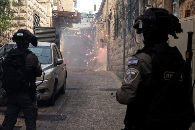 Palestinci mečejo petarde in ognjemetne rakete, izraelska mejna policija pa odgovarja.&nbsp;FOTO: Ammar Awad/Reuters
