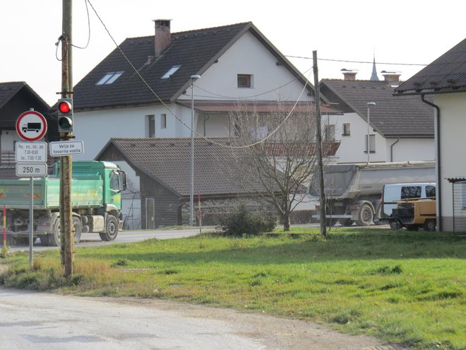 Težki tovornjaki vsak dan vozijo skozi naselje ob Gorenjski cesti. FOTO: Bojan Rajšek/Delo
