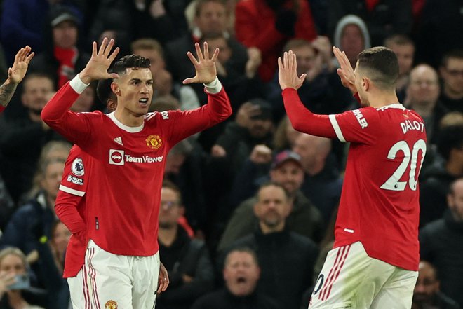 Cristiano Ronaldo in Diogo Dalot po izenačujočem golu Uniteda. FOTO: Phil Noble/Reuters
