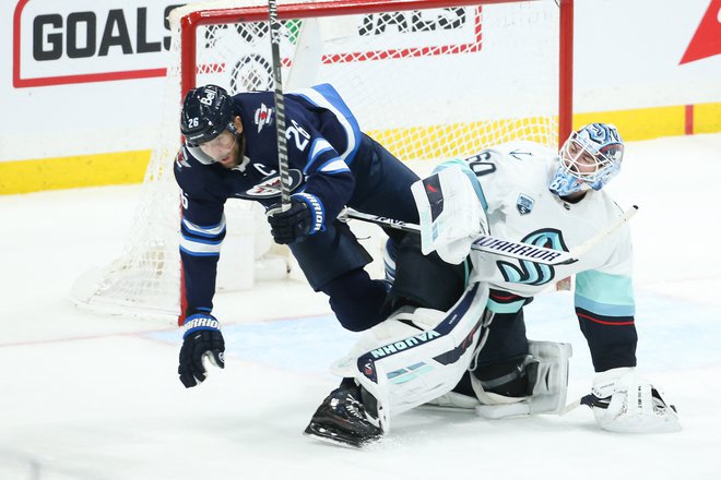 Blake Wheeler je poletel prek gostujočega vratarja&nbsp;Chrisa&nbsp;Driedgerja&nbsp;v zadnji tretjini dvoboja v dvorani Canada Life Centre. FOTO:&nbsp;Terrence Lee/USA Today Sports
