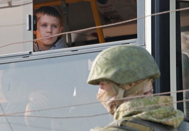 Fant gleda z okna, preden ga bodo odpeljali iz začasnega centra v Bezimennu. FOTO: Alexander Ermochenko/Reuters
