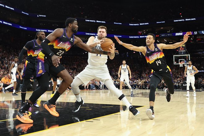 Ko je Luka Dončić ušel svojim zunanjim spremljevalcem, ga je pod obročem pričakal precej višji Deandre Ayton (22). Foto Christian Petersen/AFP
