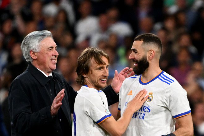 Carlo Ancelotti in njegova aduta Luka Modrić ter Karim Benzema. FOTO: Gabriel Bouys/AFP
