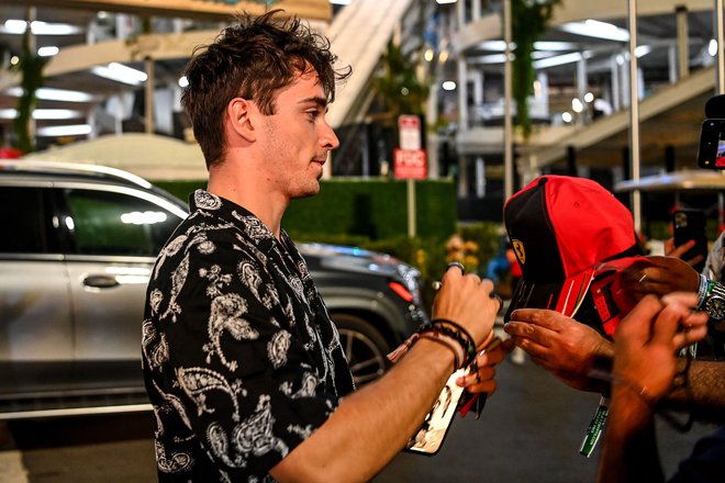 Charles Leclerc med podpisovanjem navijaških artikolv po zadnjem prostem treningu v Miamiju. FOTO: Chandan Khanna/AFP
