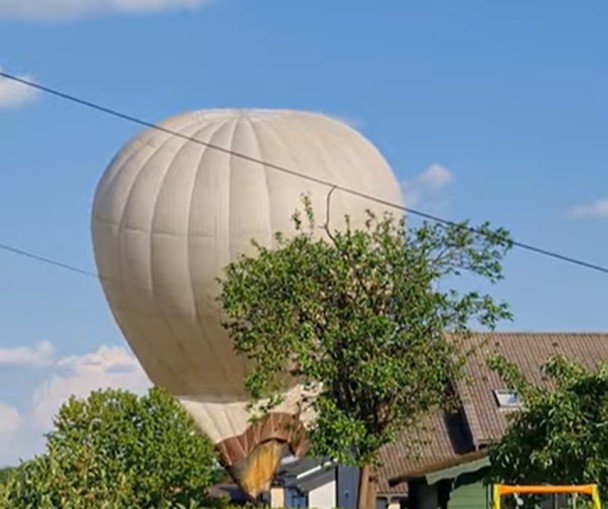 Balon je nenadoma izgubil višino in trčil v električno napeljavo, kar ga je tudi poškodovalo. FOTO: zajem zaslona/Youtube
