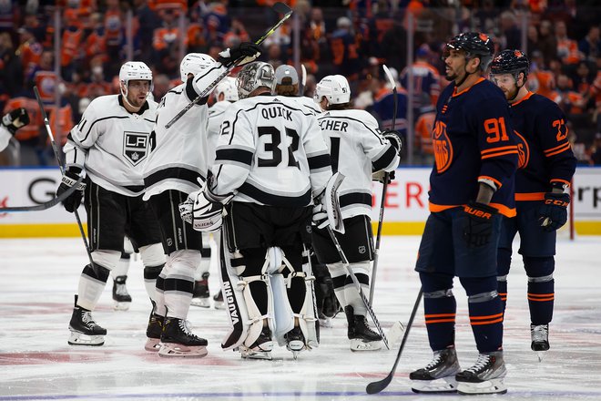 Hokejisti LA Kings proslavljajo z vratarjem Jonathanom Quickom po odločilnem zadetku Adriana Kempeja v podaljšku pete tekme. FOTO: Codie Mclachlan/AFP
