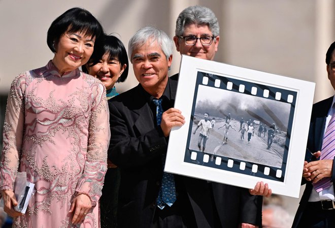 Vietnamsko-ameriški fotograf Nick Ut drži fotografijo z naslovom &raquo;Napalm Girl&laquo;, na kateri je punčka Kim Phuc, za katero je leta 1972 prejel Pulitzerjevo nagrado in nagrado World Press Photo, ko se je na Trgu svetega Petra v Vatikanu udeležil tedenske splošne avdience papeža Frančiška. Foto: Alberto Pizzoli/Afp
