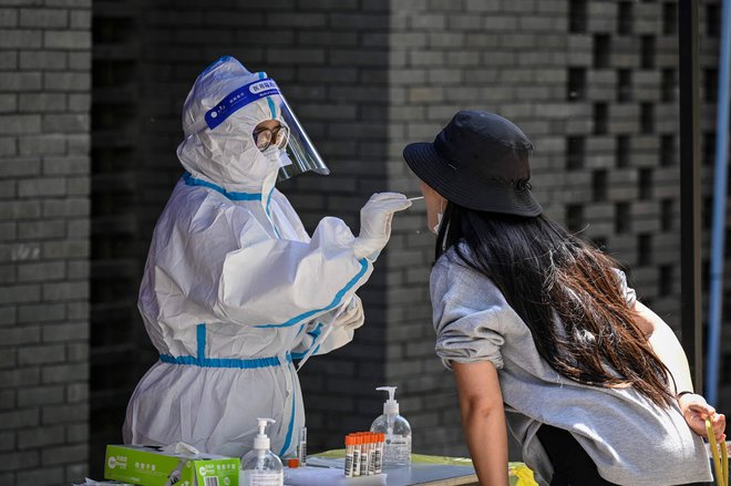 Sobotni odvzem brisa v Pekingu. FOTO: Jade Gao/AFP
