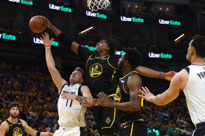 Kevon Looney ustavlja Luko Dončića na prvi tekmi v dvorani Chase Center. FOTO:&nbsp;Harry How/AFP
