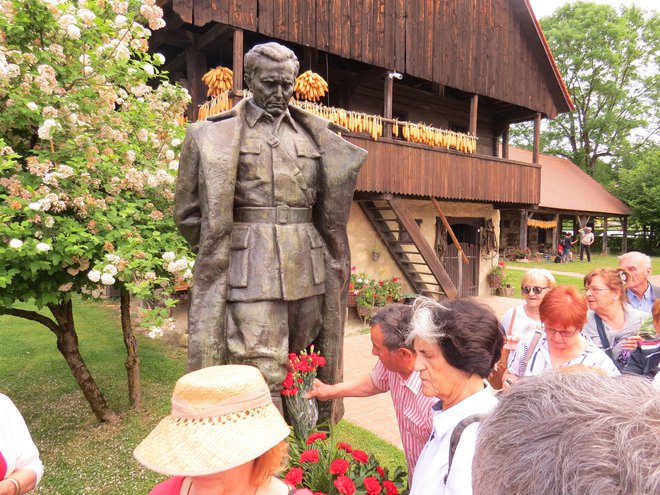 Pred spomenik Josipa Broza Tita, ki stoji zraven njegove rojstne hiše, so številni polagali cvetje. FOTO: Bojan Rajšek/Delo
