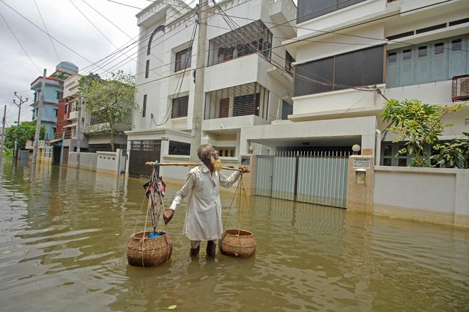 Okoli 60 ljudi je umrlo, od tega 50 v Indiji, najmanj deset pa v regiji Sylhet v Bangladešu (na fotografiji) FOTO: Mamun Hossain/AFP
