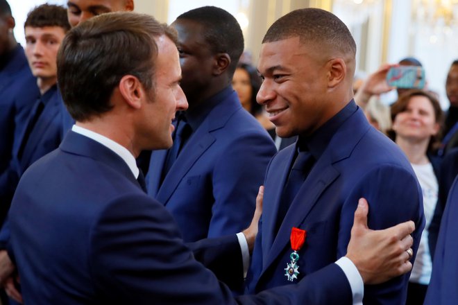 Francoski predsednik Emmanuel Macron in Kylian Mbappe po tem, ko je Francija leta 2018 postala svetovni prvak. FOTO: Francois Mori/AFP
